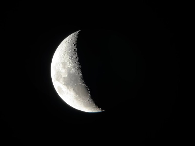 A crescent moon is seen in the dark sky.