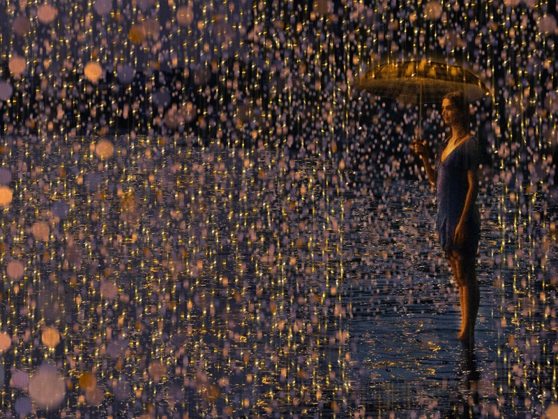 a woman is standing in the water with an umbrella.