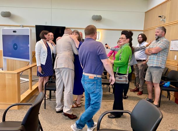 a group of people standing in a courtroom.
