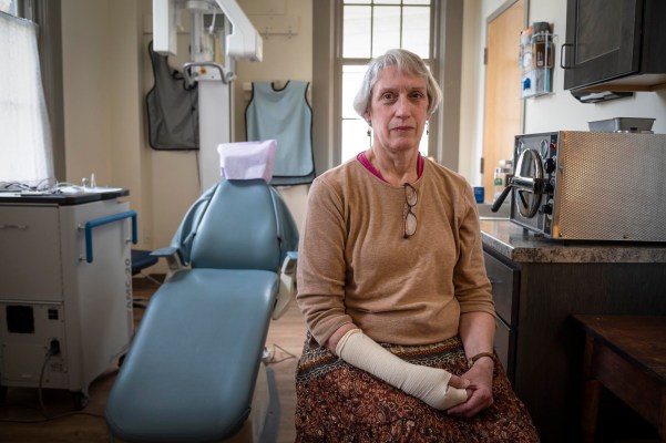 a woman sitting in a room with a cast on her arm.