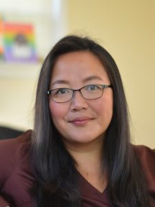 a woman wearing glasses sitting in a chair.