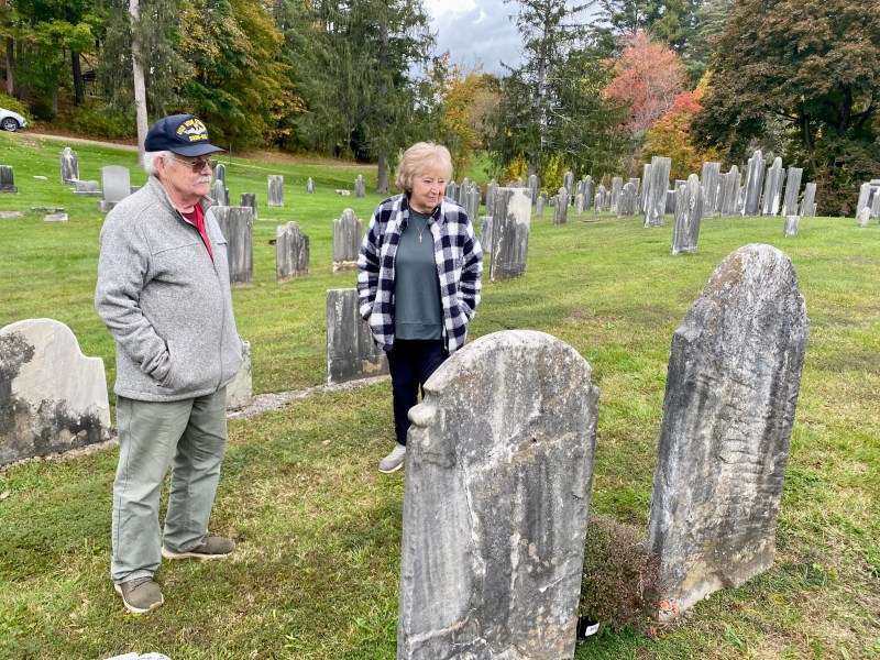 three people look at gravestones