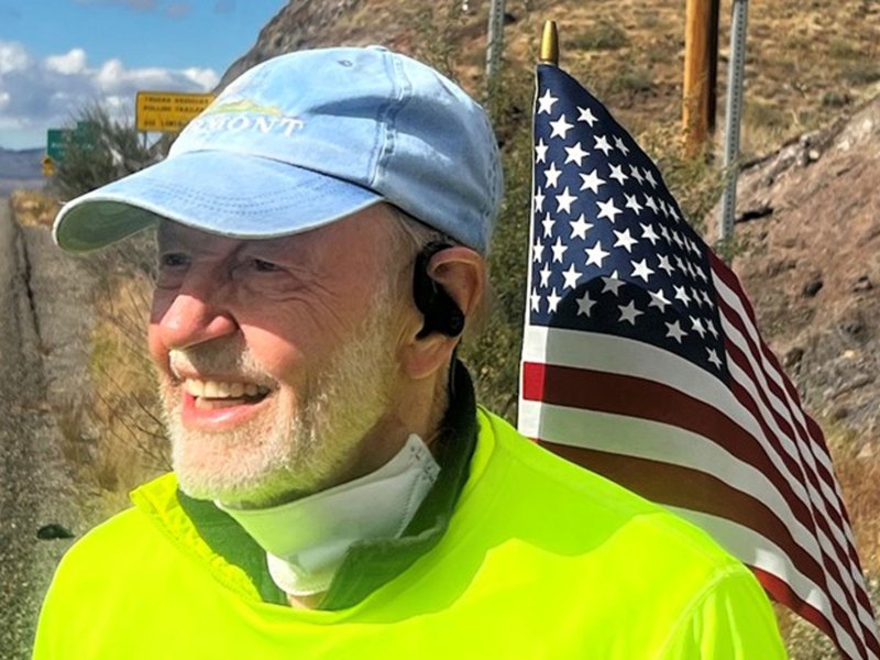 An older man wearing a hat and an american flag.