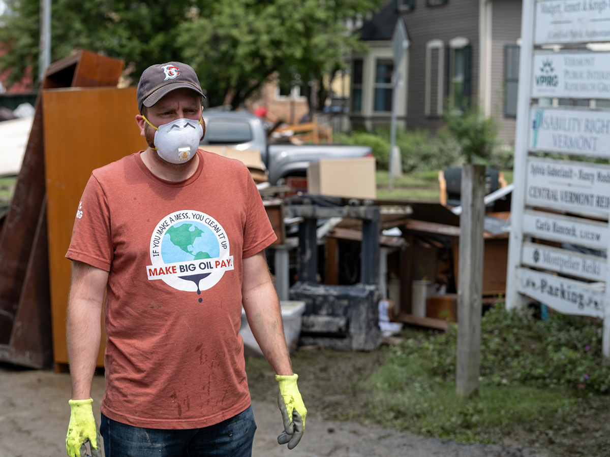 A man wearing a mask in front of a pile of trash.