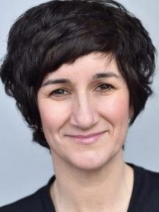 A woman with short hair smiling at the camera.