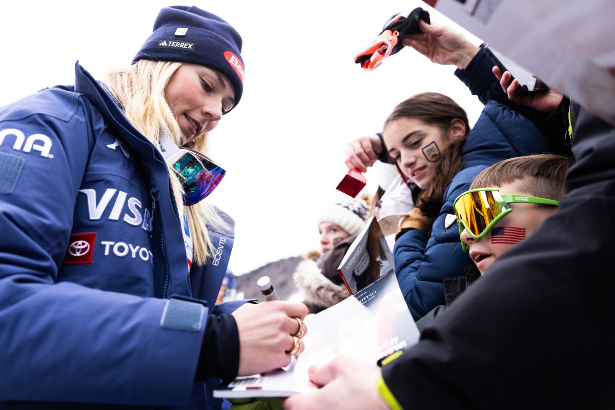 A woman signing an autograph in a crowd.