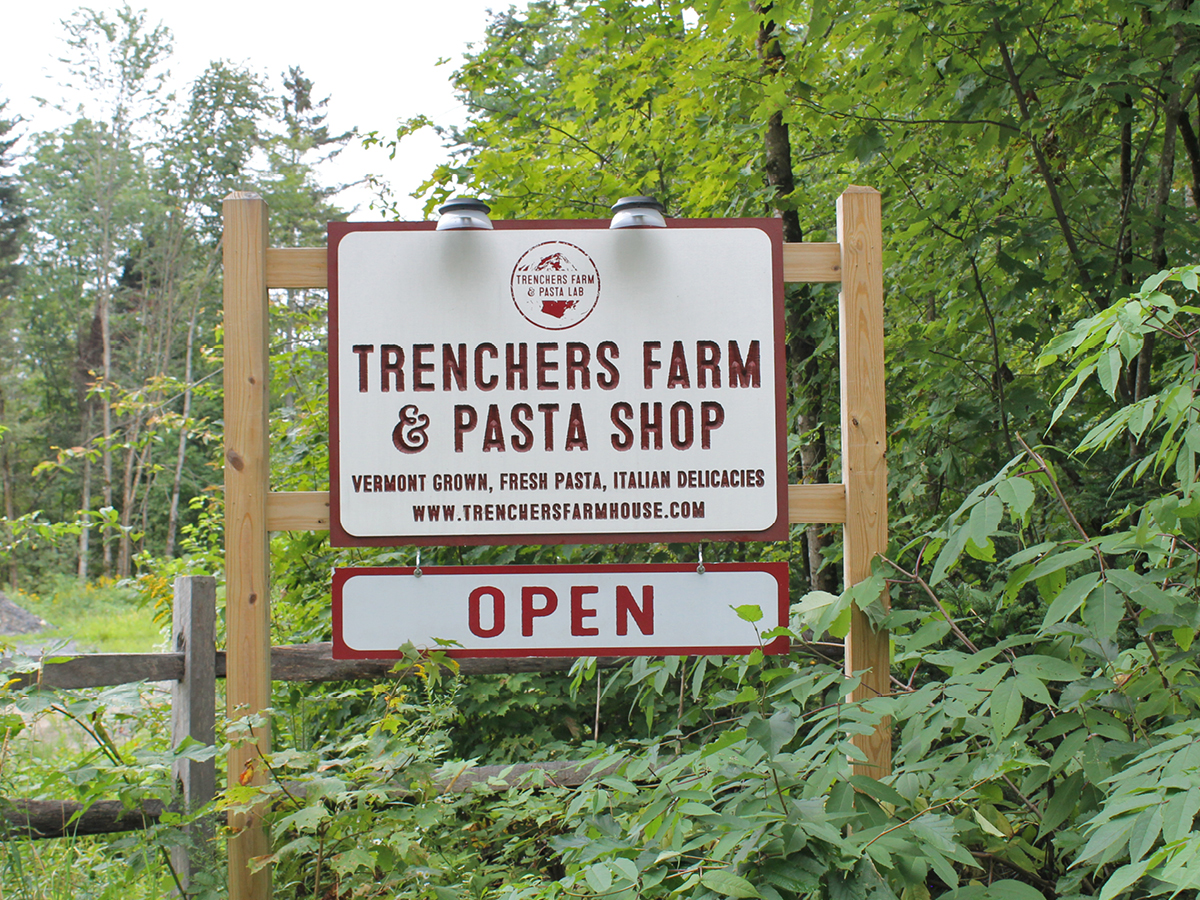 A sign for trenchers farm and pasta shop.