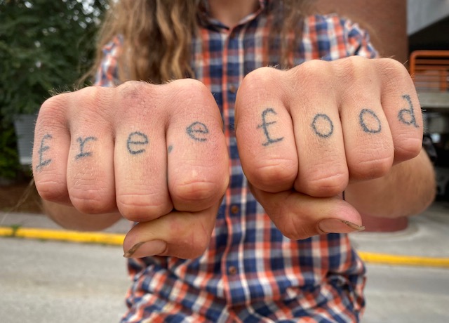 two fists with tattoed letters on fingers