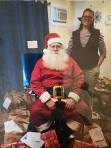 A photo of santa claus sitting in a chair.