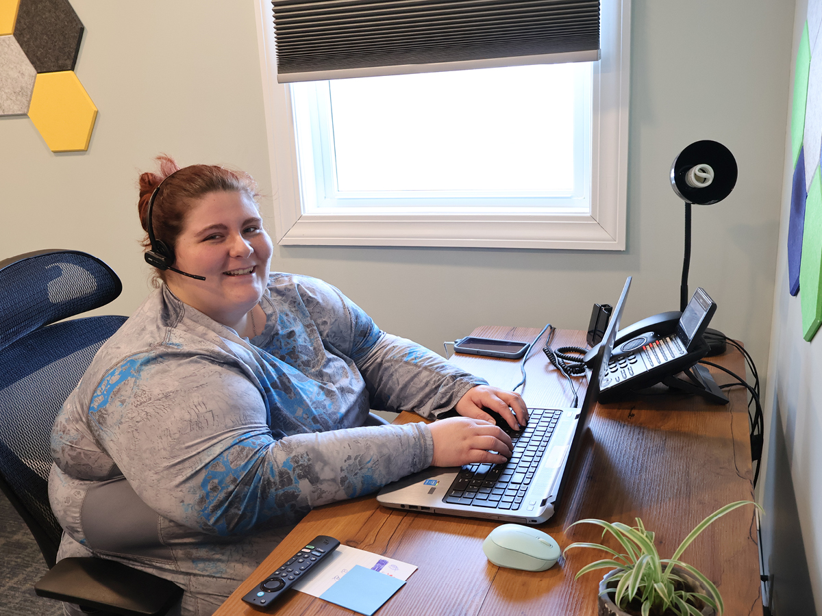A woman sitting at a desk with a laptop.