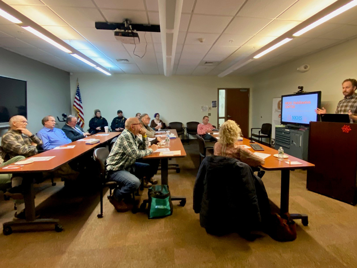 A group of people sitting around a table in a conference room.