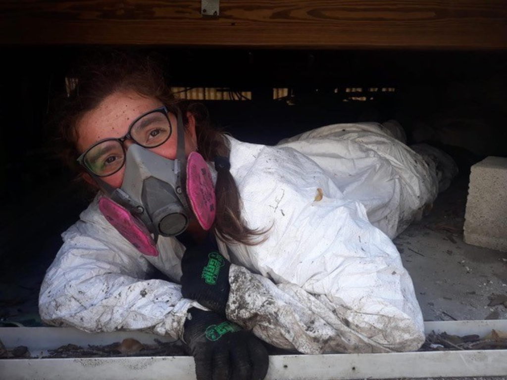 A woman in a mask laying in a basement.