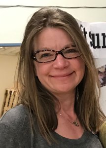 A smiling woman in glasses