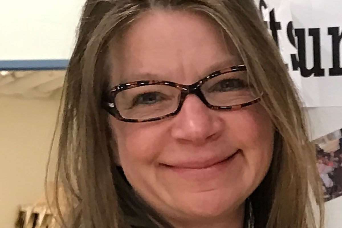 A smiling woman in glasses