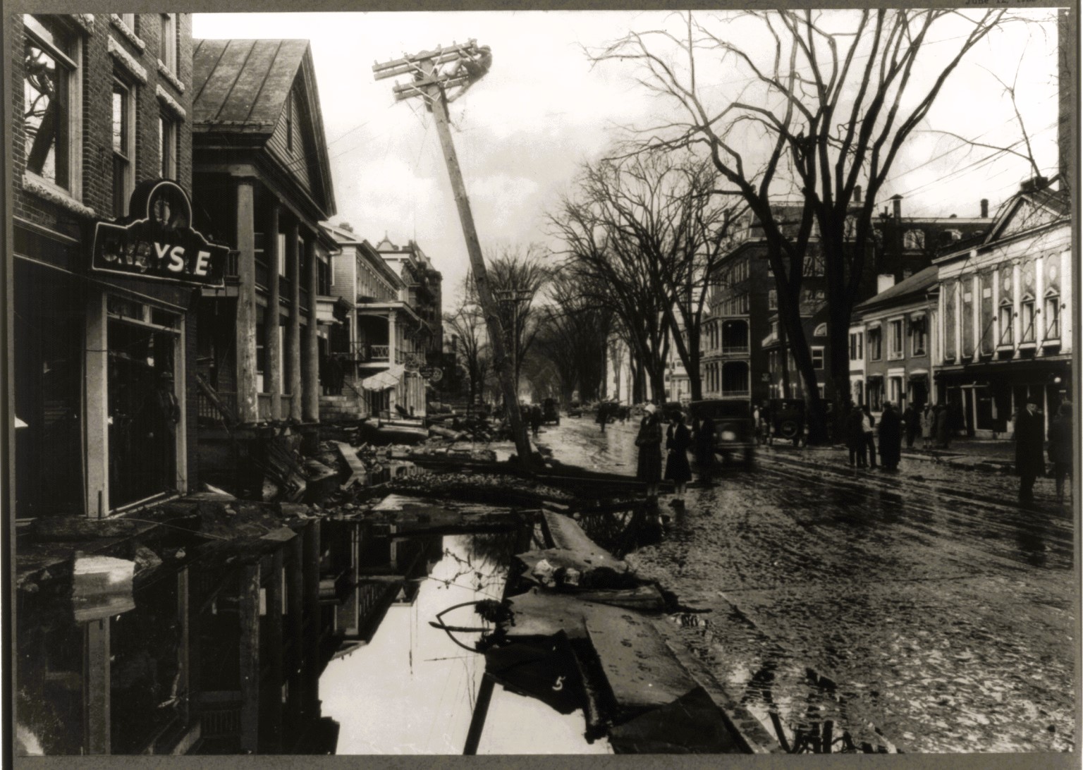 A black-and-white photo of a flood-damaged street.
