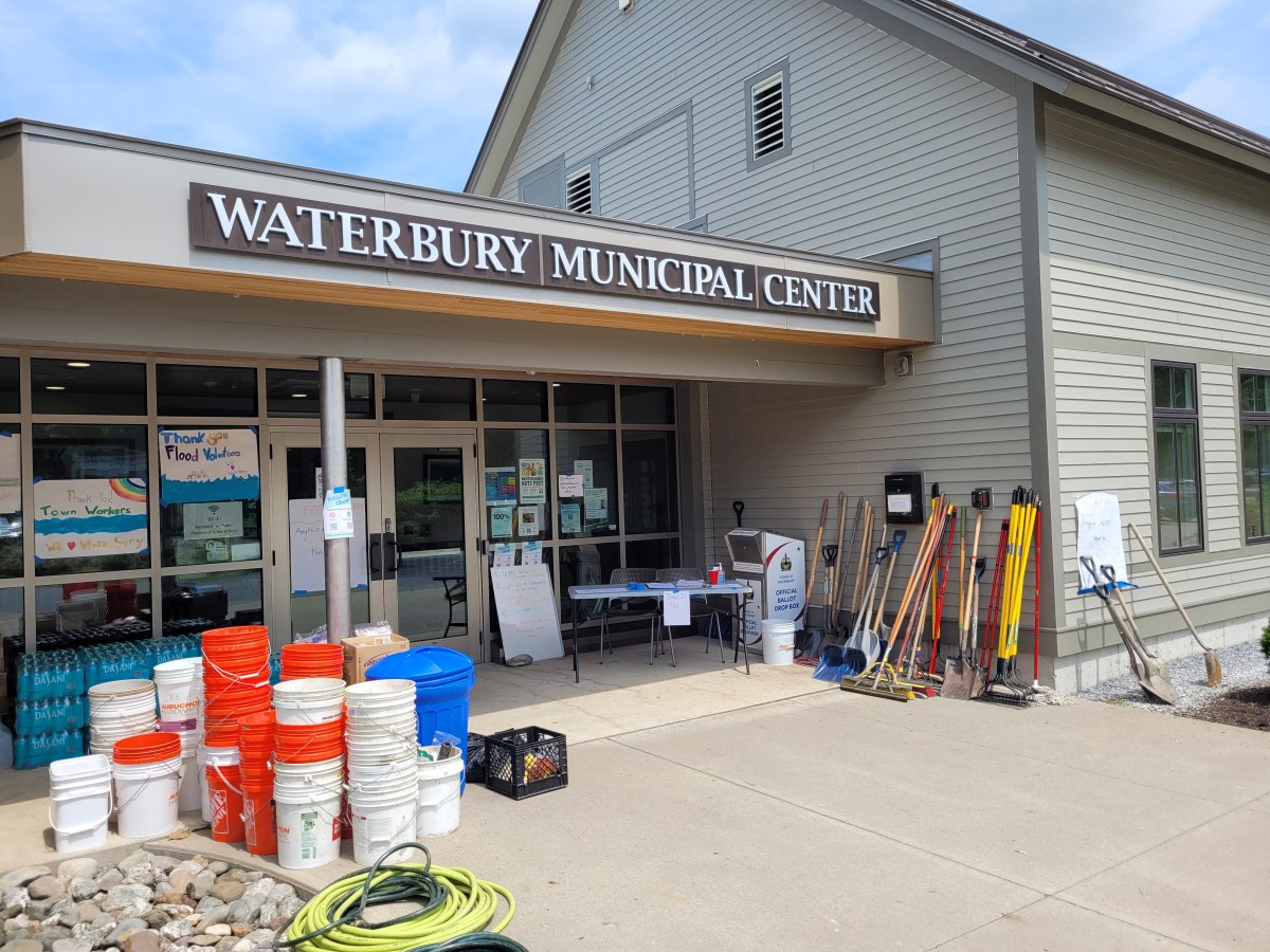 Front entrance of Waterbury Municipal Center with various buckets, tools, and supplies arranged outside the building.
