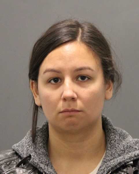 A headshot of a woman with straight dark hair, wearing a grey sweater and black jacket, looking directly at the camera with a neutral expression.