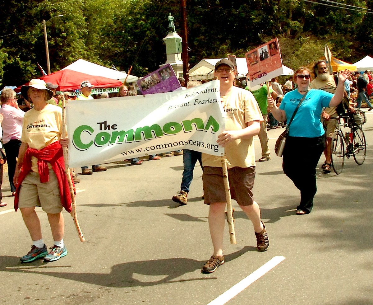 People holding a sign as they march in a parade