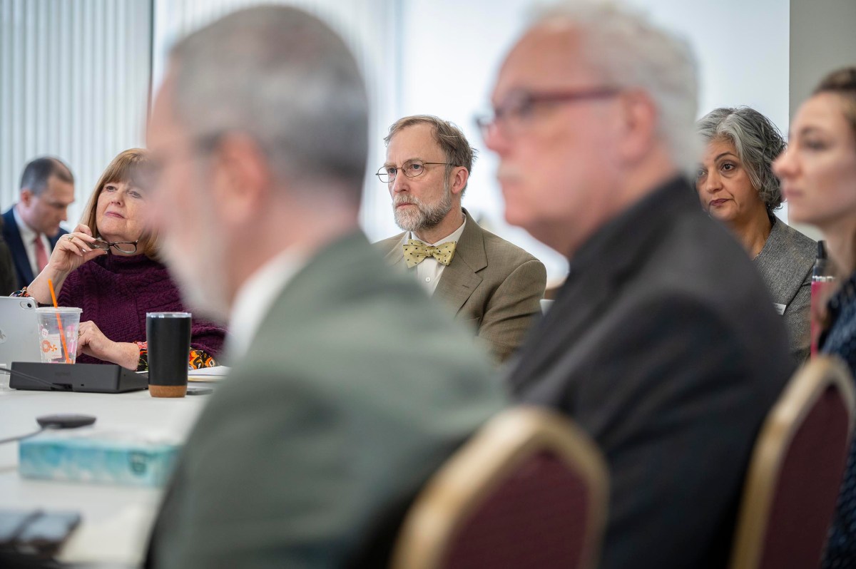 People seated around a conference table, engaged in discussion.