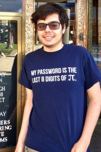 A person wearing sunglasses and a blue shirt that reads, "MY PASSWORD IS THE LAST 8 DIGITS OF π," stands smiling in front of a glass door.