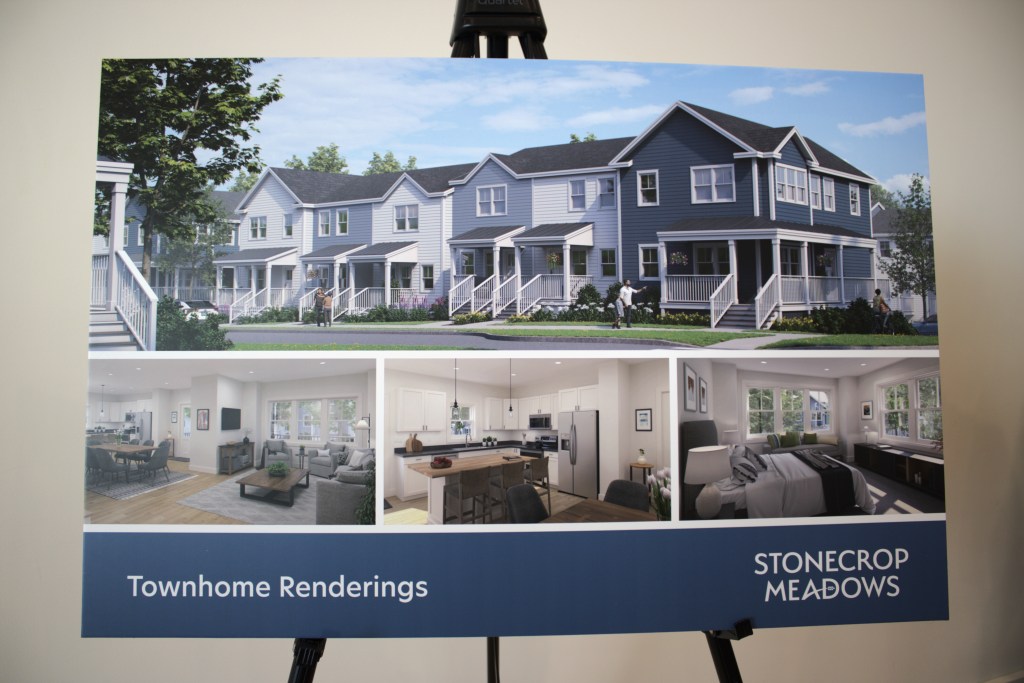 A poster displays renderings of townhomes with exterior and interior views, labeled 