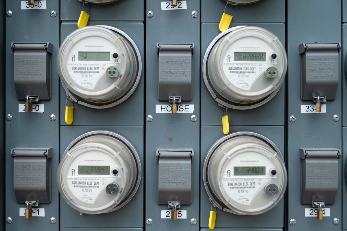 Close-up view of six electrical meters mounted on a gray panel, each labeled with a number and some covered by protective flaps.