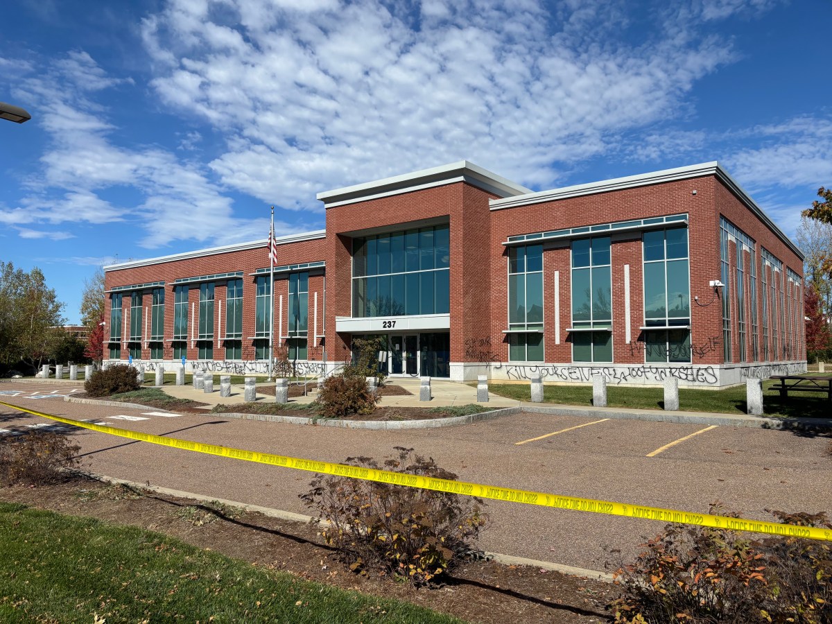 A brick building with graffiti and yellow police tape