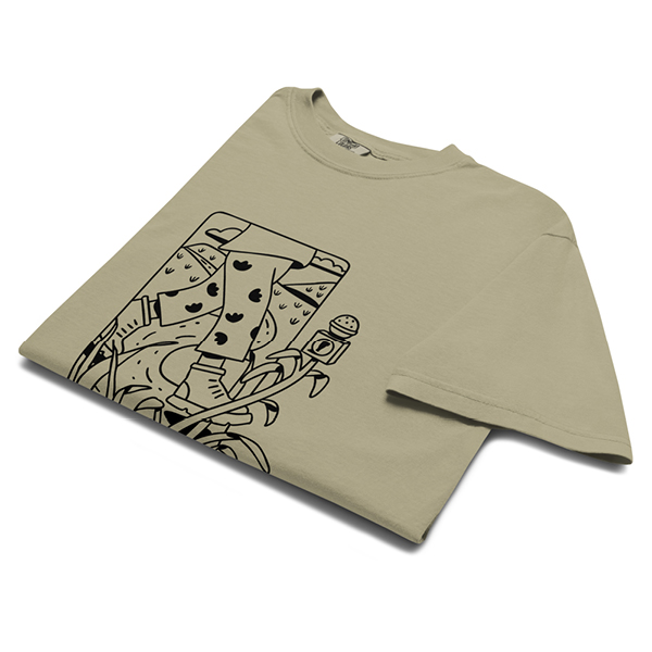 A beige, folded t-shirt featuring a black line art illustration of a person walking on a dirt road