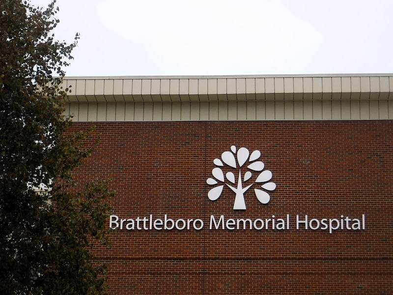 Exterior brick wall of Brattleboro Memorial Hospital with a white tree logo and the hospital name displayed.