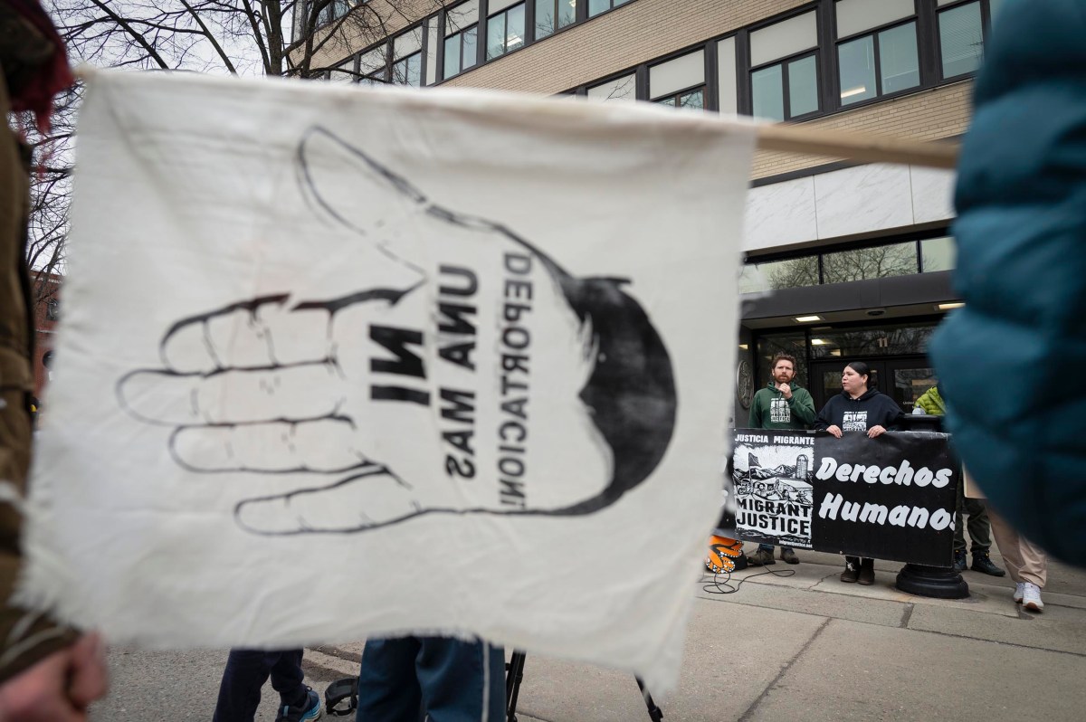 A protest scene shows a white flag with a hand graphic and Spanish text in the foreground, while people hold a “Derechos Humanos” banner outside a building in the background.