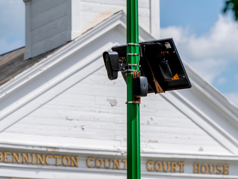 Close-up of surveillance cameras mounted on a green pole in front of the Bennington County Courthouse building.